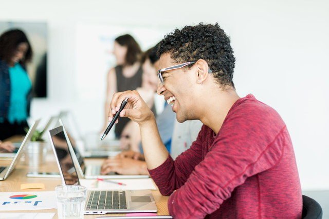 college student with laptop laughing