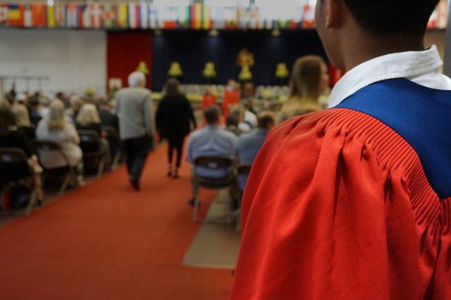 Education quotes - college graduate entering hall for ceremony.