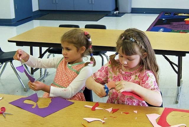 Two young girls doing a craft project on choice time.